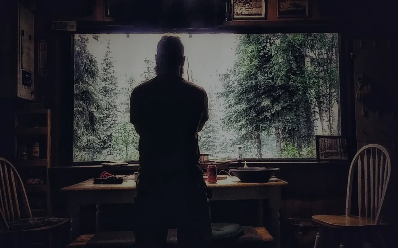 Silhouette standing at a table in a dark workspace